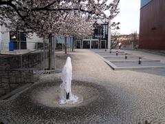 Theater courtyard with people walking and historic buildings
