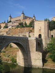 Alcántara Bridge in Toledo, Spain over the Tagus River with clear blue sky