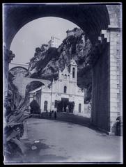 Viaduct arch and bell tower of Sainte-Dévote Church with rocky slope and street in Monaco in 1906