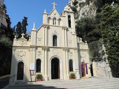 Facade of Sainte-Dévote Church in Monaco with vintage architecture under blue sky