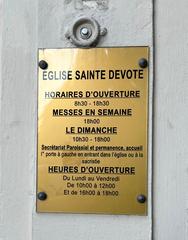 Plaque with opening hours and information at Église de Saint-Dévote in Monaco