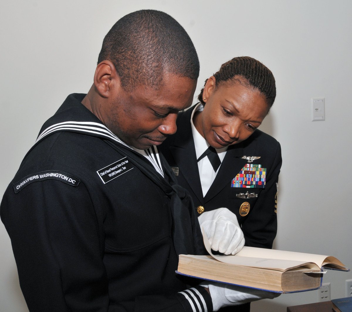 Manpower, Personnel, Training and Education Fleet Master Chief April Beldo and Yeoman 1st Class Dewayne L. Toon looking over a rare military book at the Pritzker Military Library