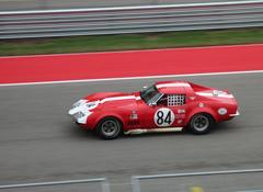 Row of vintage cars parked on grassy area at Circuit of the Americas 2014 event