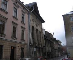 Exterior view of Synagoga Wysoka in Krakow snow covered and surrounded by leafless trees
