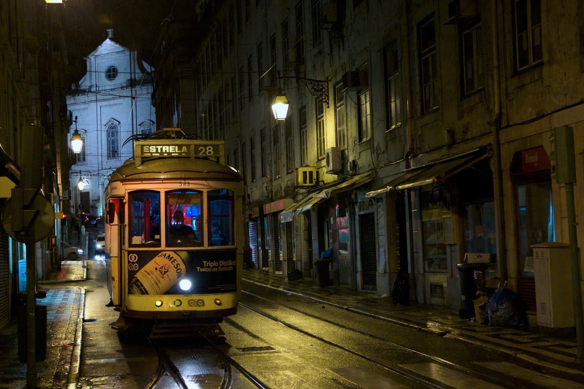 Yellow tram number 28 in Lisbon passing through historic streets