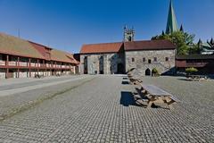 Historic Archbishop's Palace in Trondheim with colorful wooden buildings and a street lamp