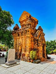 Ancient Po Nagar Cham Hindu temple complex on Mount Cù Lao, Nha Trang, Vietnam, showing brick towers and lush green surroundings