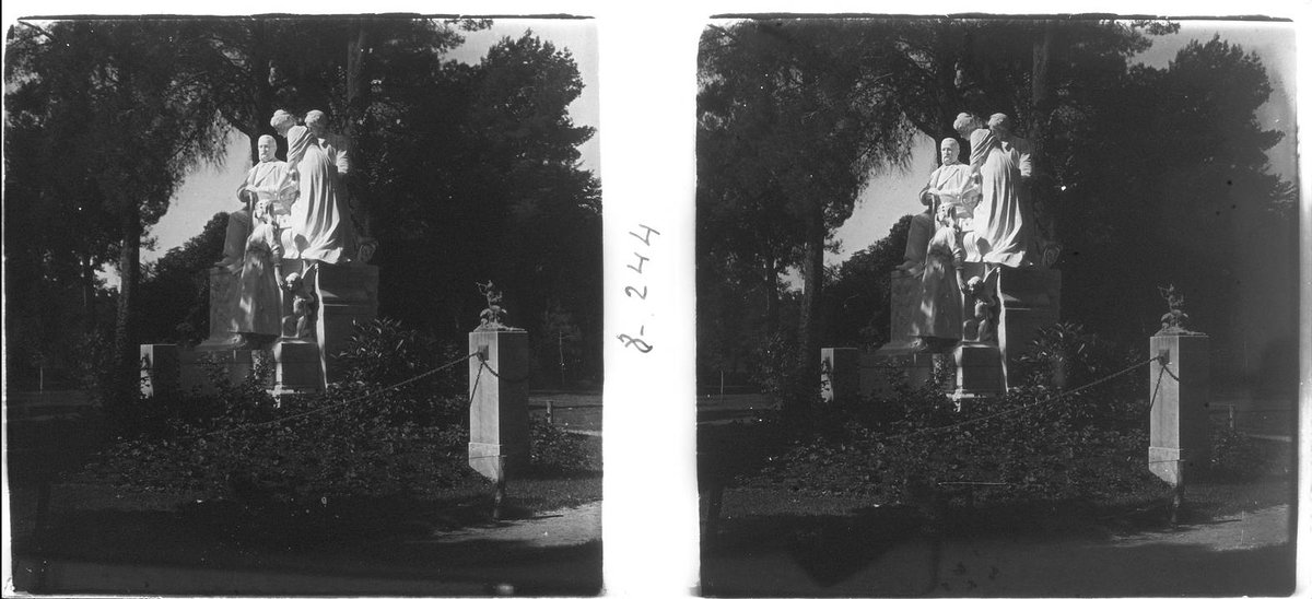 Monument to Campoamor in El Retiro Park, Madrid, bronze statue on stone pedestal with classical architecture background