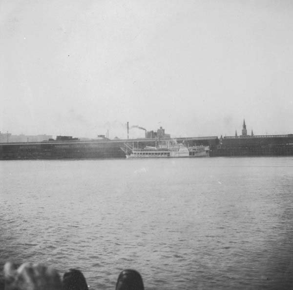 View of New Orleans French Quarter from Algiers Point across the Mississippi River with St. Louis Cathedral steeples and a paddle-wheel steamboat in 1909