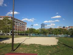 Beach volleyball courts at Drexel University's Buckley Green on a sunny day with green trees surrounding the area