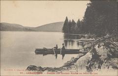 Scenic view of Lake Gérardmer with a boat by the Sentier des Roches Noires path