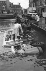 Black and white photo of milk truck sliding off the handbrake in Lijnbaansgracht canal area, Amsterdam in 1961