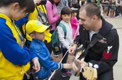 Musician teaching child to play banjo at Hong Kong Disneyland