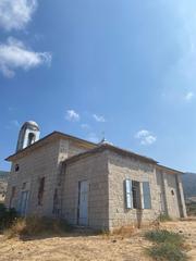 Banais Church in the Golan Heights surrounded by greenery and rocky terrain