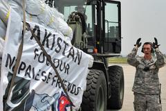 Nepalese Army and US Air Force personnel unloading relief supplies from Pakistan Air Force C-130 Hercules in Kathmandu