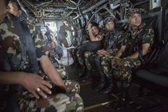 Nepalese service members looking out from a U.S Marine Corps MV-22 Osprey at Kathmandu's Tribhuvan International Airport during earthquake relief operations