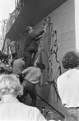 Artists painting a wooden fence around Noorderkerk in Amsterdam during Jordaanfestival in 1967