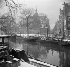 Boats in the canal with the Noorderkerk church in the background in Amsterdam during winter