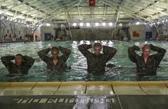 Recruits of Lima Company holding hands over heads during Water Survival Basic Qualification at Marine Corps Recruit Depot San Diego