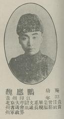 Portrait of a young man in formal attire wearing glasses