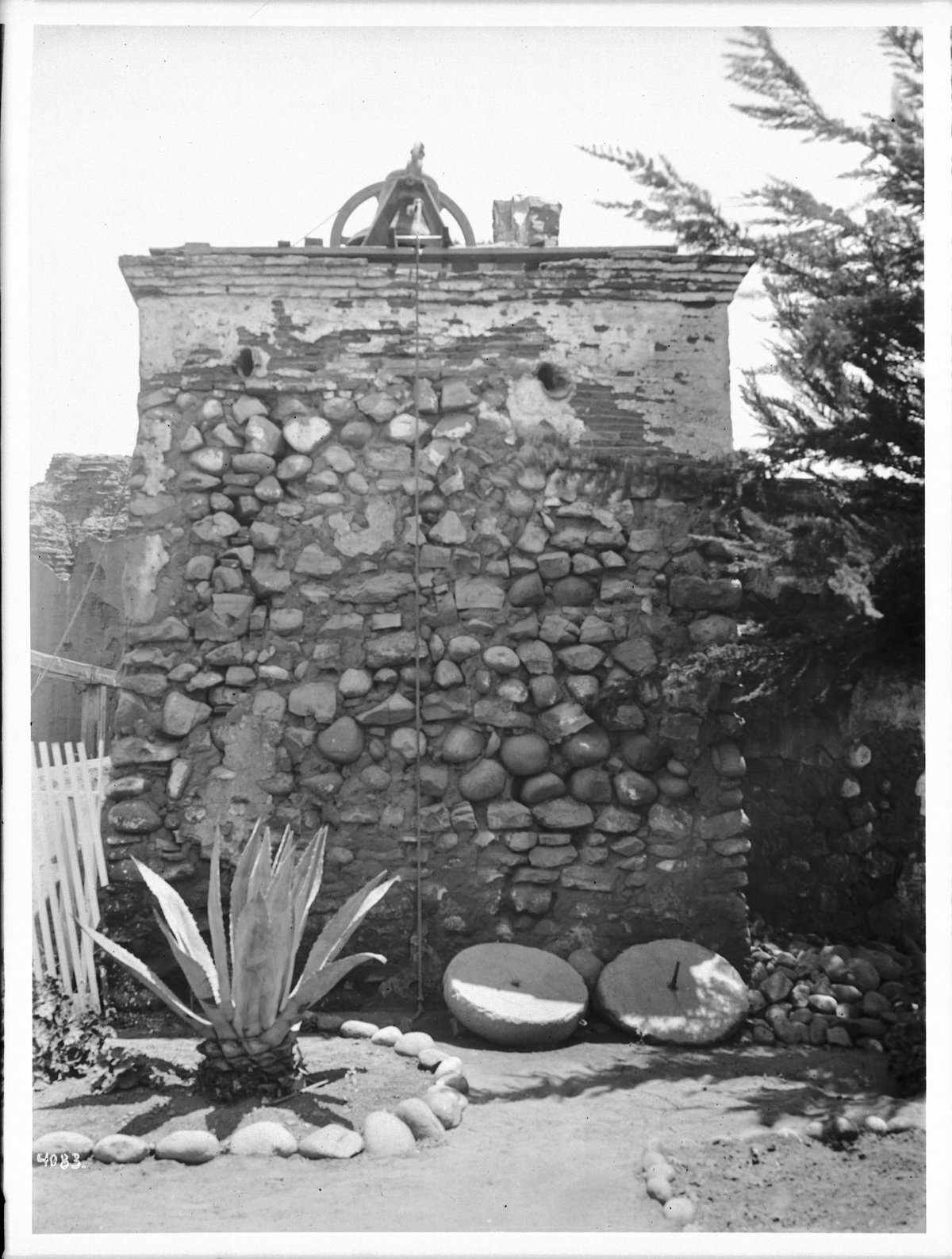 Historic bell tower at San Diego Mission with rope hanging from bell, ca.1905