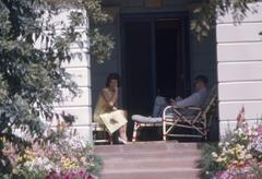 First Lady Jacqueline Kennedy taking photograph on porch of Teen Murti Bhavan with Ambassador John Kenneth Galbraith in New Delhi