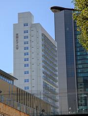 Jissen Women's University campus building in Shibuya, Tokyo under clear blue sky