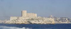 Chateau D'If fortress on a rocky island near Marseille with the city visible in the background