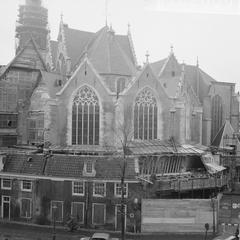 Black and white photo of De Oude Kerk with completely renewed facades, view from Oostzijde Voorburgwal on Oude Kerksplein, Amsterdam