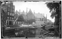 View of Oudezijds Voorburgwal canal towards Oudekerksbrug Bridge 206 and Oude Kerk church at Oudekerksplein 23 in Amsterdam, historic buildings along the canal including Oudezijds Voorburgwal 80 and 82, circa 1878