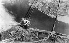 Aerial view of U.S. Air Force bombs exploding on three parallel railroad bridges over Han River near Seoul during Korean War