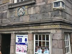 Close up of John Knox House in Edinburgh with historic inscription and Fringe Venue 30 signage