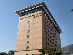 Modern Hotel Nongshim building with large windows and a vibrant cityscape background