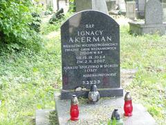 Grave of Ignacy Akerman with tombstone and surrounding greenery in a cemetery