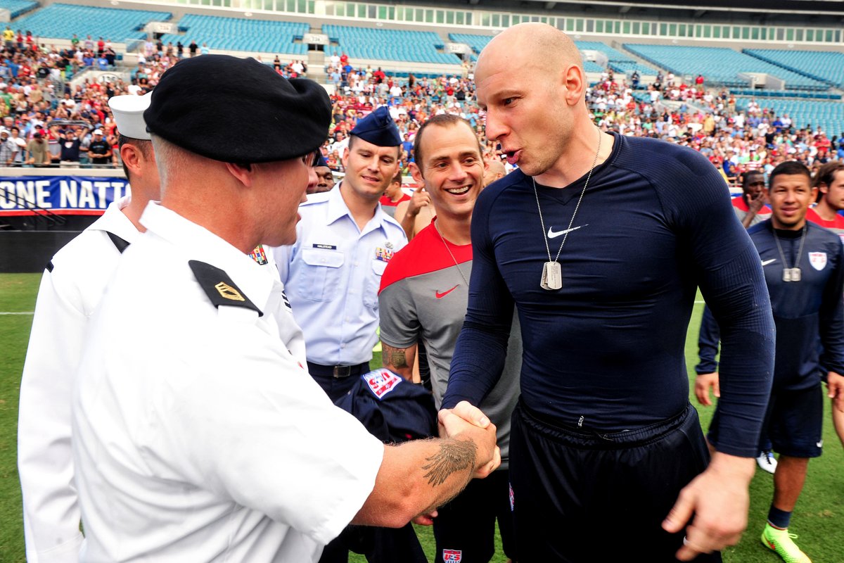 U.S. Men's National Soccer Team member shaking hands with a soldier during dog tag ceremony