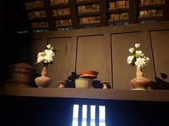 Shelf with water offerings and containers inside Siam Society Headquarters in Bangkok Thailand