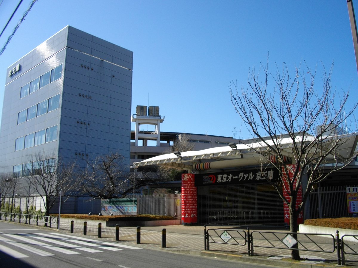 Keiokaku Velodrome outdoor cycling track with seating stands under a clear sky