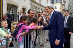 U.S. Secretary of State John Kerry shakes hands with a young girl on Rue du marché-aux-Herbes in Luxembourg City