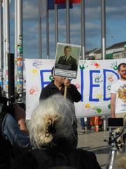 Demonstrant holding peace sign flag at Monday peace demonstration in Hamburg Jungfernstieg June 2014