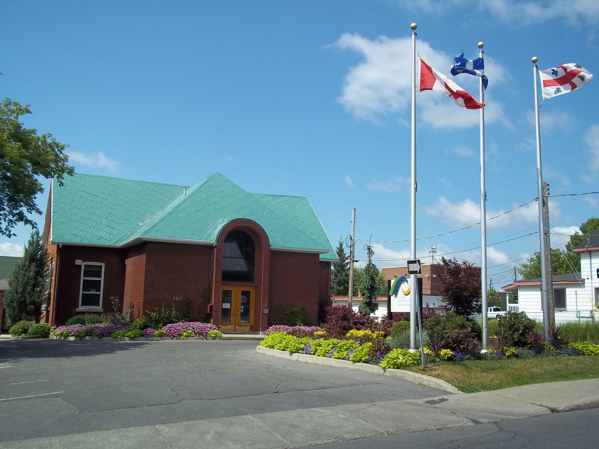 Scenic view of L'Île-Bizard village school in Montreal, Canada with greenery and clear sky