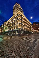 Hotel Torni building in Helsinki at dusk with illuminated windows and surrounding cityscape