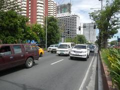 Busy street view of Roxas Boulevard in Malate, Manila with vehicles and pedestrians near major landmarks