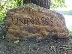 Stone with inscription UNTERSEE beside a body of water