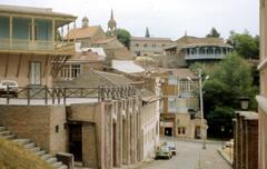 A street in Tbilisi with traditional architecture and parked cars