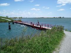 Leslie Street Spit with calm water and rocky shoreline under a partly cloudy sky