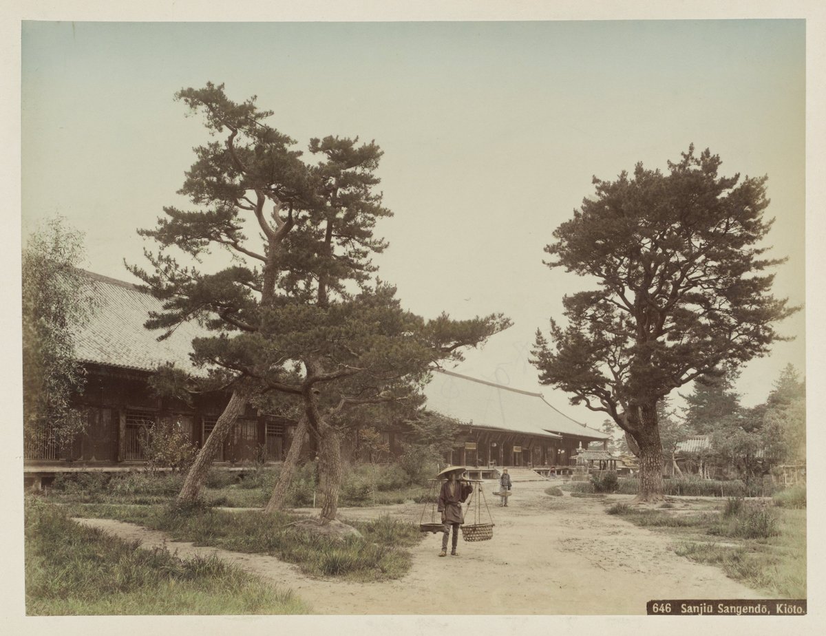 Sanjiu Sangendo Temple in Kyoto with a man carrying a pole in traditional attire in foreground