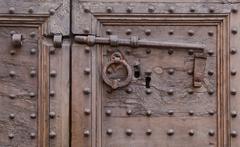 Close-up view of antique door handles and lock on a wooden door in Florence, Italy