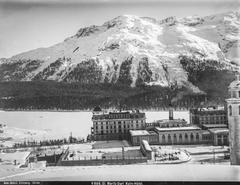 St. Moritz hotel Kulm with frozen lake and forested mountain slope in the background