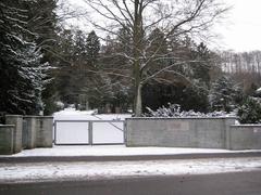 Entrance to Fluntern Cemetery in Zurich, Switzerland with stone gate and metal archway