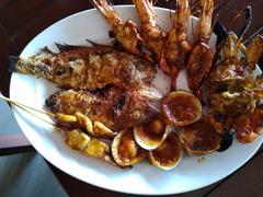 Seafood platter with fish, shrimp, crab, clams, and squid served at a beach restaurant in Jimbaran Bali